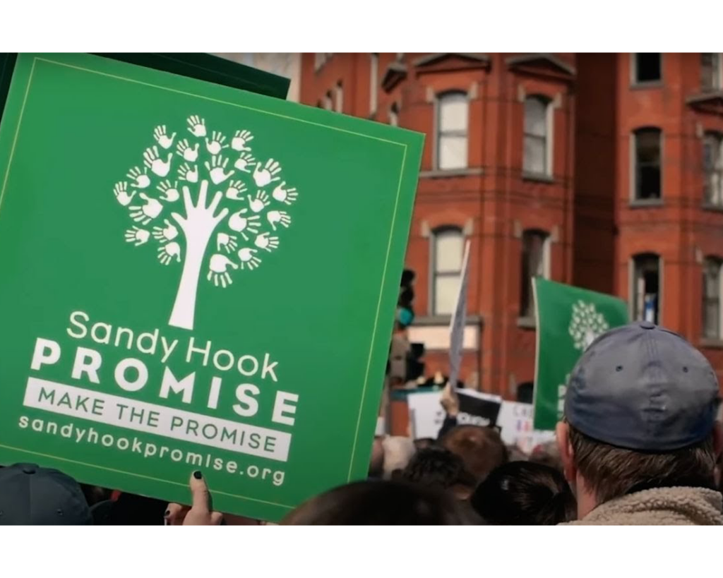 A person holds a Sandy Hook Promise sign at a public rally.