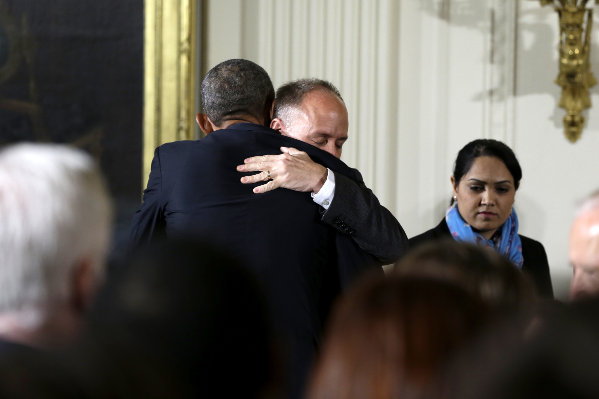 President Barack Obama hugs Mark Barden, founder and managing director of Sandy Hook Promise after he introduced the president in the East Room of the White House in Washington, Tuesday, Jan. 5, 2016, where the president spoke about steps his administration is taking to reduce gun violence. Also on stage are stakeholders, and individuals whose lives have been impacted by the gun violence. (AP Photo/Carolyn Kaster)