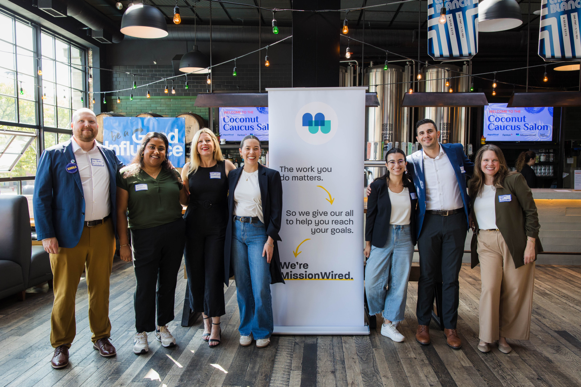 Seven MissionWired staff members posing at our Coconut Caucus Salon event ahead of the DNC.